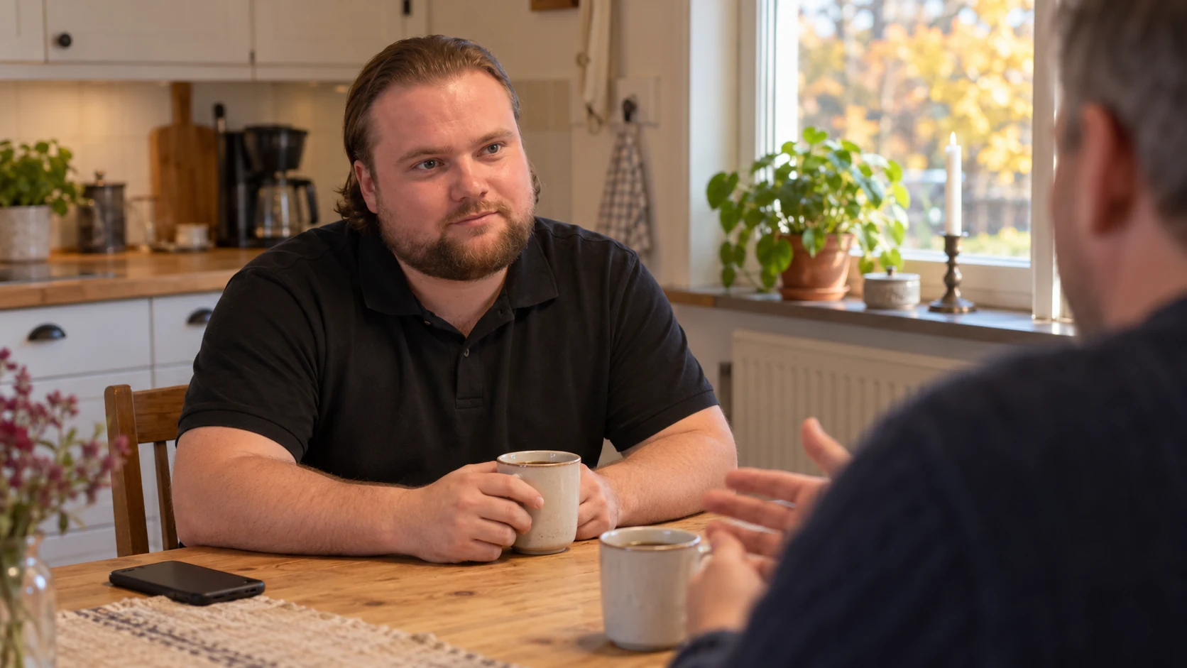 AI-genererad bild av Max Koriander som lyssnar på en vän över kaffe vid ett köksbord