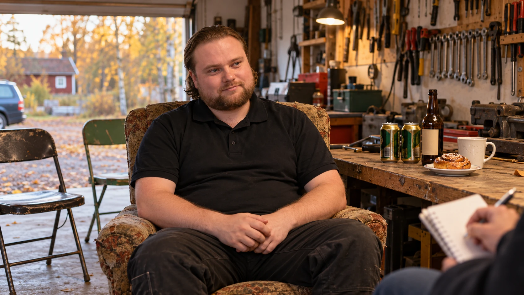 AI-genererad bild av Max Koriander som sitter vaken och leende i en fåtölj under en intervju i garaget, med öl, kaffe och en bulle på arbetsbänken